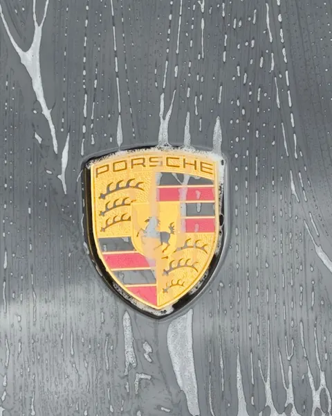 Porsche-Wappen unter Schaum bei der Handwäsche